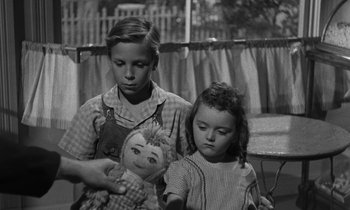 Movie still from “The Night of the Hunter” (1955), directed by Charles Laughton – A boy and a little girl holding a doll; Close Up shot, Over the shoulder angle