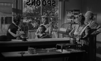 Movie still from “The Night of the Hunter” (1955), directed by Charles Laughton – An old photo of a woman and a child in a kitchen; Medium shot, Over the shoulder angle