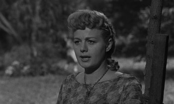 Movie still from “The Night of the Hunter” (1955), directed by Charles Laughton – A black - and - white photo of a woman in a floral dress; Close Up shot, Low angle