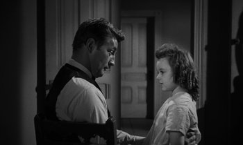 Movie still from “The Night of the Hunter” (1955), directed by Charles Laughton – A man and a girl are holding each other; Medium shot, Over the shoulder angle