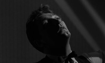 Movie still from “The Night of the Hunter” (1955), directed by Charles Laughton – A black and white photo of a man looking up; Close Up shot, Low angle