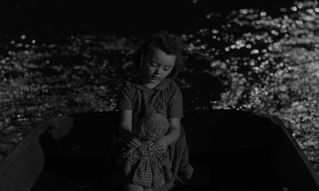 Movie still from “The Night of the Hunter” (1955), directed by Charles Laughton – A little girl holding a teddy bear in her hands; Close Up shot, High angle