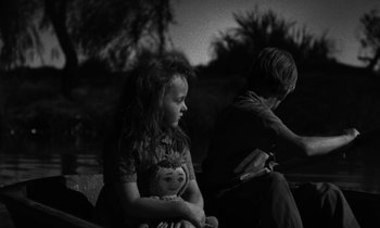 Movie still from “The Night of the Hunter” (1955), directed by Charles Laughton – A girl and a boy sitting on the ground; Close Up shot, High angle