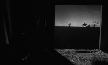 Movie still from “The Night of the Hunter” (1955), directed by Charles Laughton – A black and white photo of a man riding a horse; Extreme Wide shot, Low angle