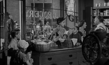 Movie still from “The Night of the Hunter” (1955), directed by Charles Laughton – A black and white photo of people in a store; Wide shot, Over the shoulder angle