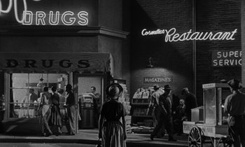 Movie still from “The Night of the Hunter” (1955), directed by Charles Laughton – A black - and - white photo of people walking down the street; Extreme Wide shot, Low angle