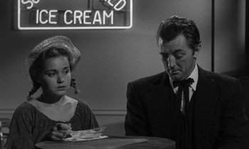 Movie still from “The Night of the Hunter” (1955), directed by Charles Laughton – A man and a woman sitting at a table in front of a ice cream sign; Medium shot, Over the shoulder angle