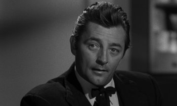 Movie still from “The Night of the Hunter” (1955), directed by Charles Laughton – Black and white photograph of a man wearing a suit and tie; Close Up shot, Low angle