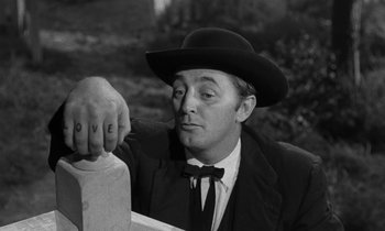 Movie still from “The Night of the Hunter” (1955), directed by Charles Laughton – A black and white photo of a man in a suit and hat; Close Up shot, Low angle