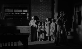 Movie still from “The Night of the Hunter” (1955), directed by Charles Laughton – A group of people standing in front of a brick wall; Wide shot, Low angle