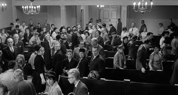 Movie still from “The Night of the Iguana” (1964), directed by John Huston – A large group of people sitting in a room; Wide shot, High angle