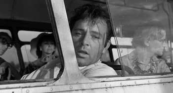 Movie still from “The Night of the Iguana” (1964), directed by John Huston – A black and white photo of a man in a car; Close Up shot, Low angle