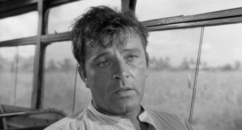 Movie still from “The Night of the Iguana” (1964), directed by John Huston – Black and white photograph of a man in a field; Close Up shot, Low angle