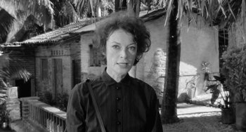Movie still from “The Night of the Iguana” (1964), directed by John Huston – Black and white photograph of a woman in front of a house; Close Up shot, Low angle