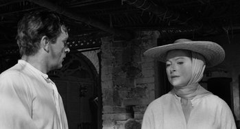 Movie still from “The Night of the Iguana” (1964), directed by John Huston – A man and a woman standing next to each other in front of a brick wall; Close Up shot, Over the shoulder angle