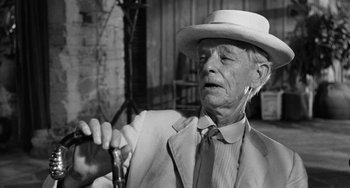 Movie still from “The Night of the Iguana” (1964), directed by John Huston – An older man wearing a white hat and a suit; Close Up shot, Over the shoulder angle