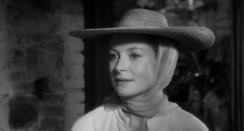 Movie still from “The Night of the Iguana” (1964), directed by John Huston – A black and white photo of a woman wearing a hat; Close Up shot, Over the shoulder angle