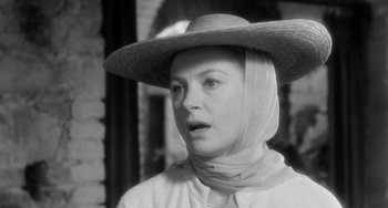 Movie still from “The Night of the Iguana” (1964), directed by John Huston – A black and white photo of a woman wearing a hat; Close Up shot, Over the shoulder angle