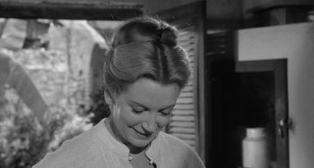 Movie still from “The Night of the Iguana” (1964), directed by John Huston – A black and white photo of a woman with a bun; Close Up shot, Over the shoulder angle
