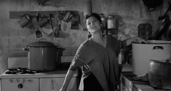 Movie still from “The Night of the Iguana” (1964), directed by John Huston – A black and white photo of a woman in a kitchen; Medium shot, High angle