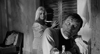 Movie still from “The Night of the Iguana” (1964), directed by John Huston – A man and a woman sitting at a dinner table; Medium shot, Low angle