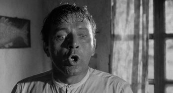 Movie still from “The Night of the Iguana” (1964), directed by John Huston – A black and white photo of a man with wet hair; Close Up shot, Low angle