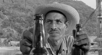 Movie still from “The Night of the Iguana” (1964), directed by John Huston – An old man holding two beer bottles in his hands; Close Up shot, Low angle