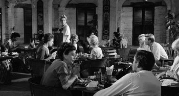 Movie still from “The Night of the Iguana” (1964), directed by John Huston – A black and white photo of people sitting at a restaurant; Wide shot, High angle