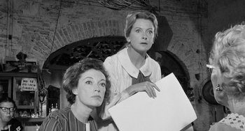 Movie still from “The Night of the Iguana” (1964), directed by John Huston – A black - and - white photo of two women holding a piece of paper; Medium shot, Low angle