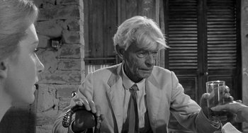 Movie still from “The Night of the Iguana” (1964), directed by John Huston – An older man sitting in front of a brick wall; Close Up shot, Over the shoulder angle