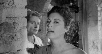 Movie still from “The Night of the Iguana” (1964), directed by John Huston – Two women standing next to each other near a brick wall; Close Up shot, Low angle