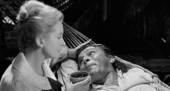 Movie still from “The Night of the Iguana” (1964), directed by John Huston – A man and a woman are laying in a hammock; Close Up shot, High angle
