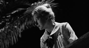 Movie still from “The Night of the Iguana” (1964), directed by John Huston – A woman in a dress and a bow tie looking to her left; Close Up shot, Low angle