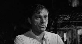 Movie still from “The Night of the Iguana” (1964), directed by John Huston – Black and white photograph of a man in a white shirt; Close Up shot, Low angle