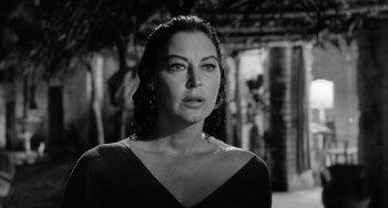 Movie still from “The Night of the Iguana” (1964), directed by John Huston – Black and white photograph of a woman in a black dress; Close Up shot, Low angle