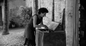 Movie still from “The Night of the Iguana” (1964), directed by John Huston – A woman standing in front of an old coke machine; Medium shot, High angle