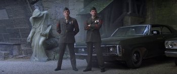 Movie still from “The Ninth Configuration” (1980), directed by William Peter Blatty – A couple of men standing next to each other in uniform; Medium shot, Low angle