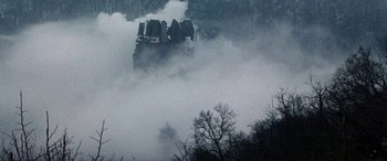 Movie still from “The Ninth Configuration” (1980), directed by William Peter Blatty – A train traveling down tracks through a dense forest; Extreme Wide shot, Low angle
