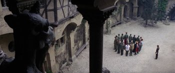 Movie still from “The Ninth Configuration” (1980), directed by William Peter Blatty – A group of people standing around a building; Extreme Wide shot, High angle