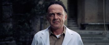 Movie still from “The Ninth Configuration” (1980), directed by William Peter Blatty – An older man wearing a white lab coat; Close Up shot, Low angle