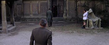 Movie still from “The Ninth Configuration” (1980), directed by William Peter Blatty – A man in a military uniform is looking at a man in a green coat; Wide shot, High angle