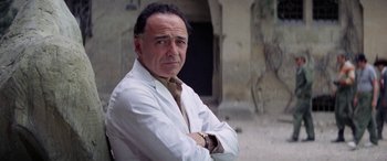 Movie still from “The Ninth Configuration” (1980), directed by William Peter Blatty – A man in a white lab coat with his arms crossed; Close Up shot, Low angle