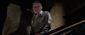 Movie still from “The Ninth Configuration” (1980), directed by William Peter Blatty – An older man in a uniform stands in front of a piano; Close Up shot, Low angle