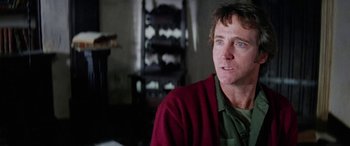 Movie still from “The Ninth Configuration” (1980), directed by William Peter Blatty – A person sitting in front of a window; Close Up shot, Low angle