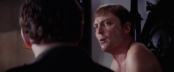 Movie still from “The Ninth Configuration” (1980), directed by William Peter Blatty – A person looking at a mirror; Close Up shot, Over the shoulder angle