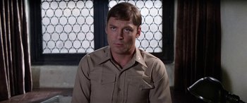 Movie still from “The Ninth Configuration” (1980), directed by William Peter Blatty – A person wearing a uniform; Close Up shot, Over the shoulder angle