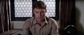 Movie still from “The Ninth Configuration” (1980), directed by William Peter Blatty – A man that is sitting down in a room; Close Up shot, Over the shoulder angle