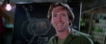 Movie still from “The Ninth Configuration” (1980), directed by William Peter Blatty – A person smiling for the camera; Close Up shot, Low angle