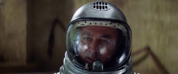 Movie still from “The Ninth Configuration” (1980), directed by William Peter Blatty – A person wearing a space suit; Close Up shot, Low angle