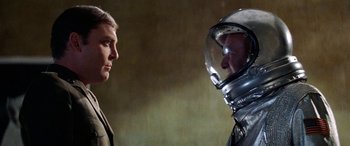 Movie still from “The Ninth Configuration” (1980), directed by William Peter Blatty – A man in a space suit and a man in a helmet; Close Up shot, Over the shoulder angle